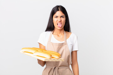 pretty hispanic chef woman feeling disgusted and irritated and tongue out and holding a tray with...