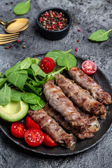 minced meat wrapped in bacon with spinach, avocado and cherry tomato, Healthy fats, clean eating for weight loss. Keto paleo diet menu. vertical image. top view. place for text