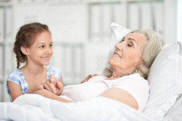 Fototapeta premium Granddaughter with grandmother sitting at home