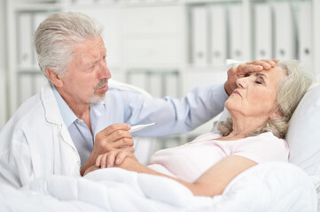 Senior woman portrait in hospital with caring doctor