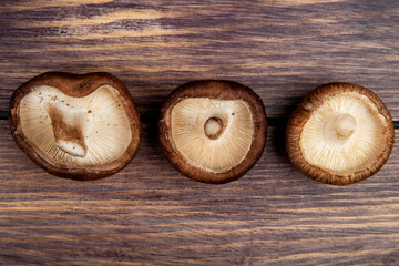 top view of fresh mushrooms lined in a row isolated on rustic wooden background
