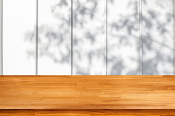 wood table with tree branch shadow on white wooden slats