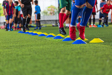 Obraz na płótnie Canvas Soccer ball tactics on grass field with barrier for training children jump skill