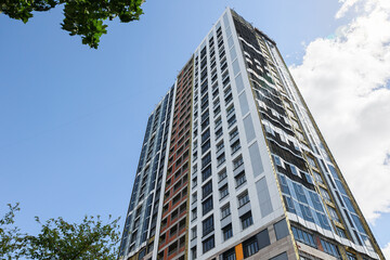 A high-rise building is under construction. metal and concrete structures. A sunny summer day.