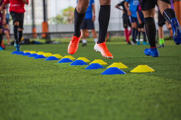 Fototapeta premium Soccer ball tactics on grass field with barrier for training children jump skill