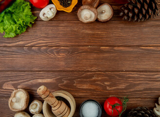 top view of fresh mushrooms with black peppercorns fresh tomatoes wooden mortar with dried herbs salt and cones on rustic wooden background with copy space