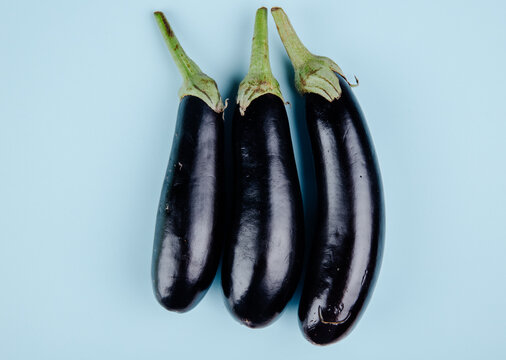 top view of fresh ripe eggplants isolated on blue background