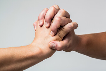 Male hand united in handshake. Man help hands, guardianship, protection. Two hands, isolated arm, helping hand of a friend. Friendly handshake, friends greeting