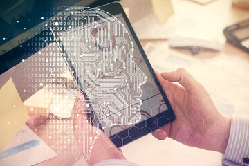 Double exposure of man's hand holding and using a digital device and brain hologram drawing. Data concept.