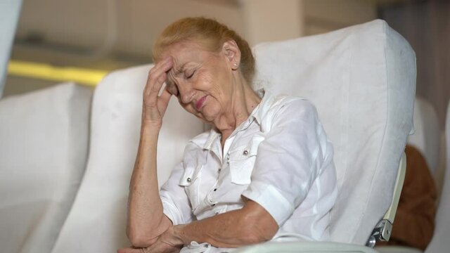 senior woman passenger headache on the plane