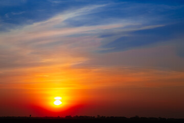 Beautiful orange  and yellow sunset sky with white clouds and blue sky with copy space. Cozy peaceful skyscape.	Dramatic colorful sunset.