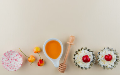 top view of fresh ripe rainier cherries with cottage cheese in mini tart tins and honey with wooden spoon on white background with copy space