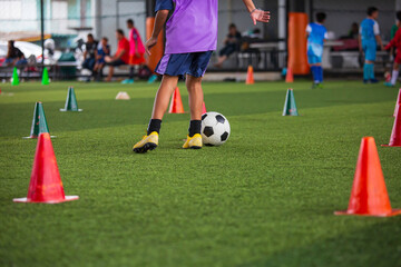 Children playing control soccer ball tactics on grass field with for training