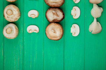 top view of fresh sliced and whole mushrooms isolated on green background with copy space