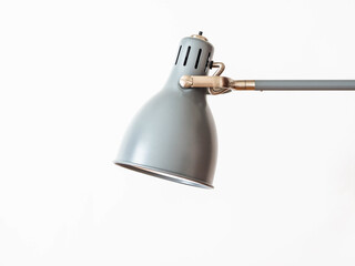 Gray home metal shade lamp with rotary mechanism on white background.