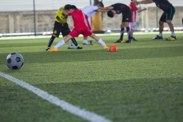 Obraz premium Soccer ball tactics on grass field with children warm up