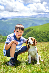 funny little boy with a dog in the mountains