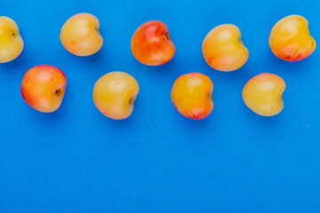 top view of ripe rainier cherries isolated on blue background with copy space