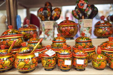 Fototapeta na wymiar Kitchen utensils in traditional Russian technique Khokhloma sugar bowls, jars