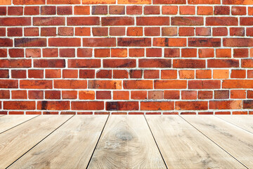 Empty wooden table with red brick wall in the background