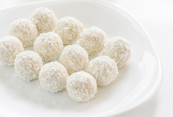 Fototapeta na wymiar White sweet coconut truffles Closeup on white background, selective focus.