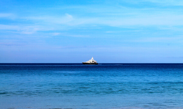 yacht in the blue sea on the horizon in the distance. High quality photo