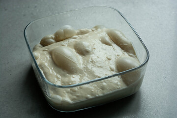 Artisan bread sourdough dough rising with bubles. Raw dough for bread or pizza.