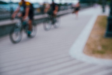 Blurred photo of people riding bicycles. Background on the theme of ecology, sports.