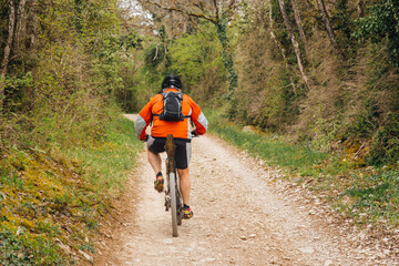 Un homme fait du vélo sur un chemin dans la forêt. Un homme pédale dans la forêt. Un cycliste dans les bois.