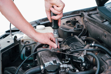 Car repair. Auto mechanic working on car engine in mechanics garage. Repair service. Close up of car mechanic repairer technician repairs auto engine