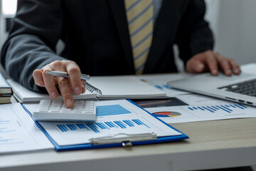 Financial Business man analyze the graph of the company's performance to create profits and growth,...
