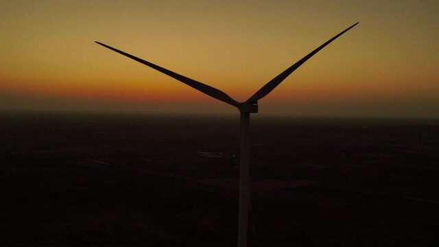 Aerial view over the farm landscape and wind turbines generating clean renewable energy. Renewable energy production for the green ecological world.