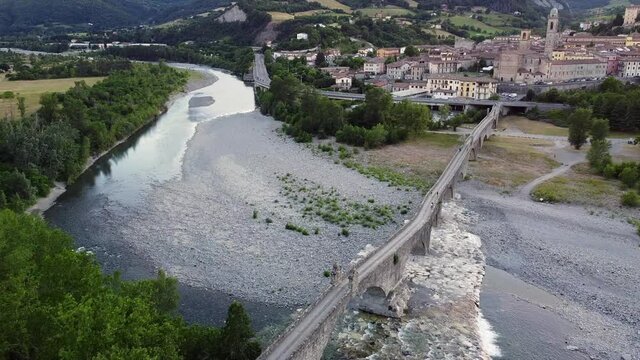 Europe, Italy , Bobbio , Piacenza ,Val Trebbia- Drone aerial view of roman historic stones bridge Ponte Gobbo o Ponte Vecchio and Bobbio village 