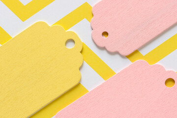 retro wooden pastel pink and yellow gift or merchandise tags or labels isolated on yellow and white...