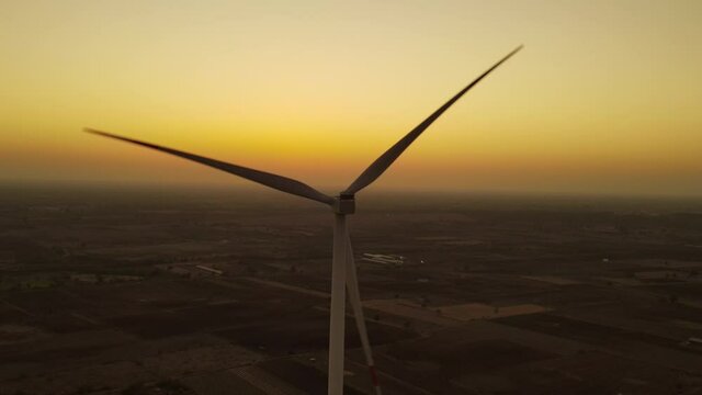 Aerial view over the farm landscape and wind turbines generating clean renewable energy. Renewable energy production for the green ecological world.