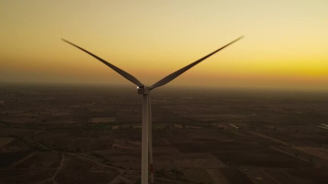 Aerial view over the farm landscape and wind turbines generating clean renewable energy. Renewable energy production for the green ecological world.