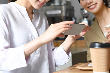  店内でスマホ撮影をする複数の女性のイメージ