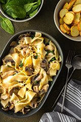Fettuccini pasta with mushrooms and chicken breast and basil in a creamy sauce, top view