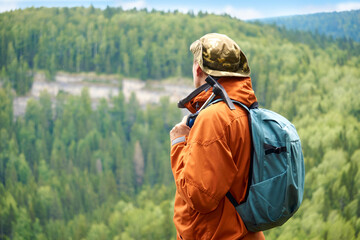 male geologist against the backdrop of a wooded mountain landscape