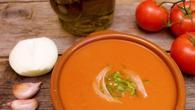 Gazpacho andaluz, made with tomatoes, onion, garlic, green bell pepper and olive oil, typical drink from the south of spain, from andalucia on a wooden base