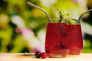 Refreshing summer chilled drinks outdoors. Two drinking glasses of cherry juice on summer...