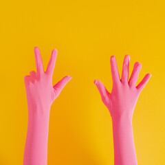 hands with pink glove and number eight on yellow sunny summer background. modern summer abstract art