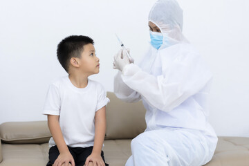Doctor vaccinating Asian little boy at doctor's office