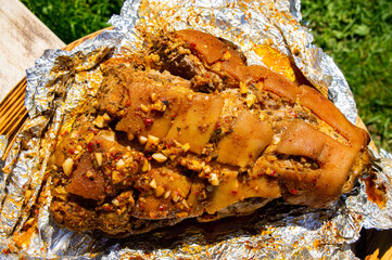 Grilled pork leg shank in foil close-up