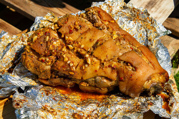 Grilled pork leg shank in foil close-up