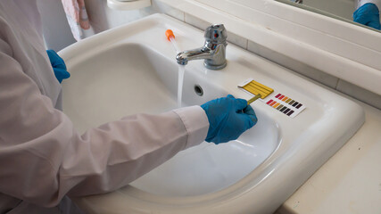 measurement of the pH of the drinking water with litmus paper in the bathroom