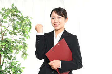  ガッツポーズをするスーツ姿の若い女性