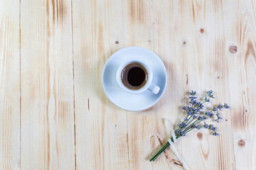 cup of coffee and lavender flowers on wooden table