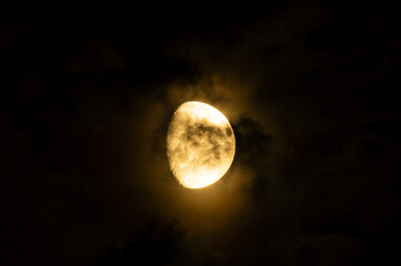 Naklejka na ściany i meble Clouds and spots on the moon. Moonlight in the black night sky