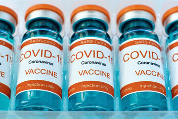 Row Bottles with covid-19 vaccine in plastic box.
